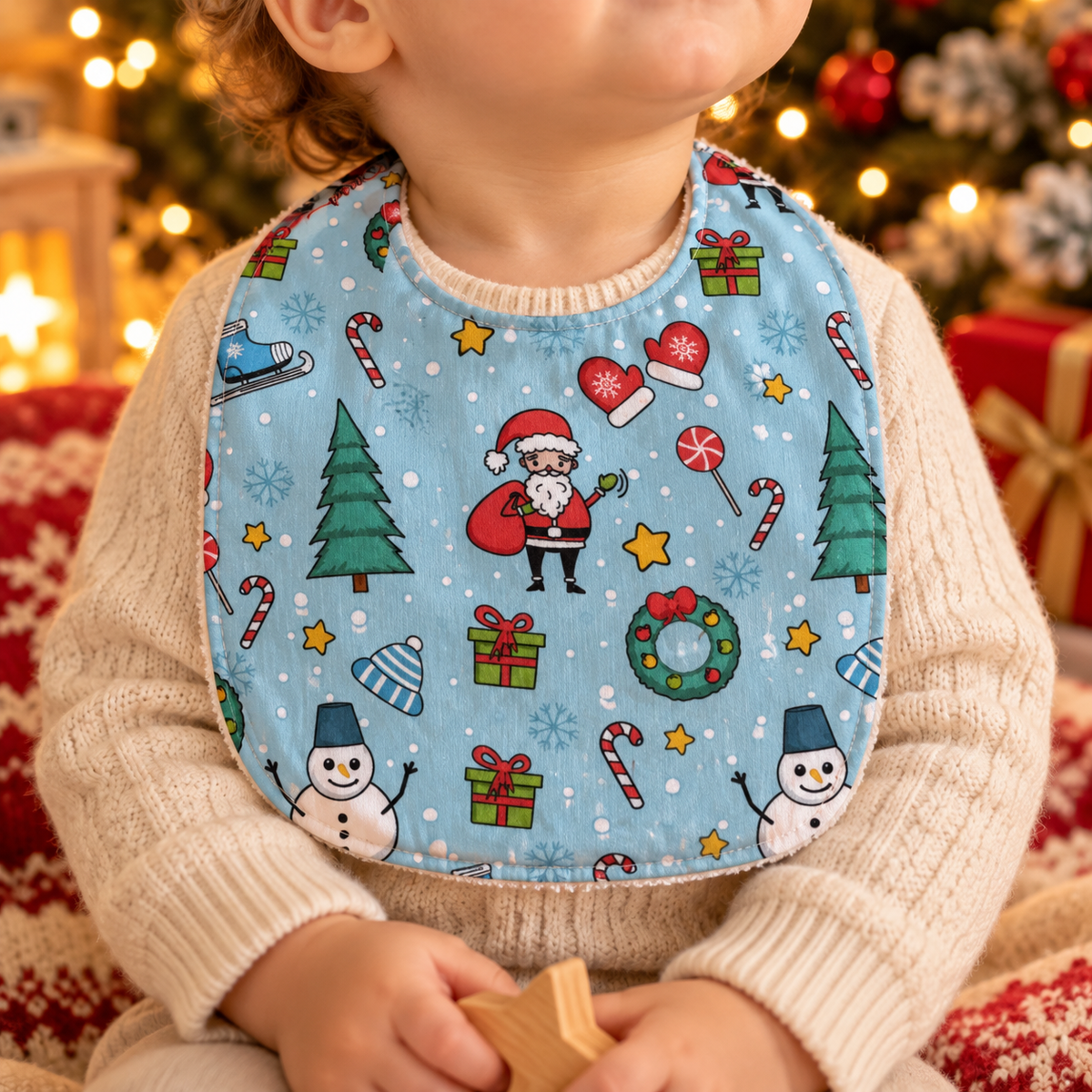 Bambino con bavetta natalizia azzurra Perrilù indossata davanti all'albero di Natal
